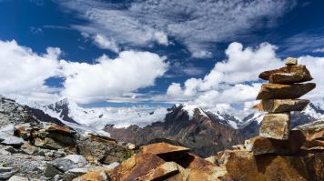 Cairns de pierre devant des sommets enneigés de la Cordillère Blanche