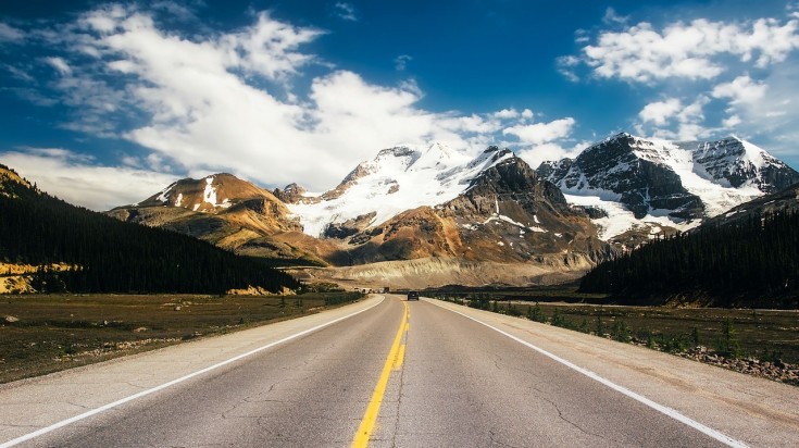 Route filant vers des montagnes enneigées dans l’Ouest canadien