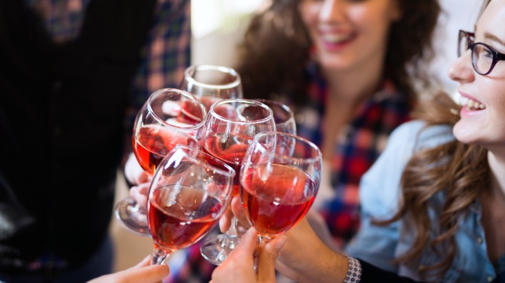 Amis trinquant avec des verres de vin rouge