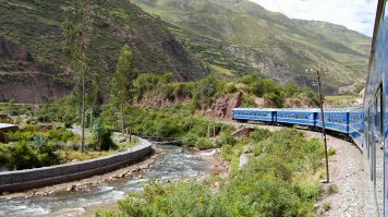 Train bleu longeant le río Urubamba dans la vallée menant au Machu Picchu