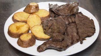 Viande grillée servie avec des pommes de terre rissolées, spécialité péruvienne