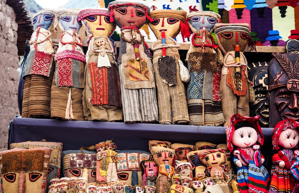 Poupées et masques en tissu traditionnel vendus sur un marché artisanal de la Vallée sacrée