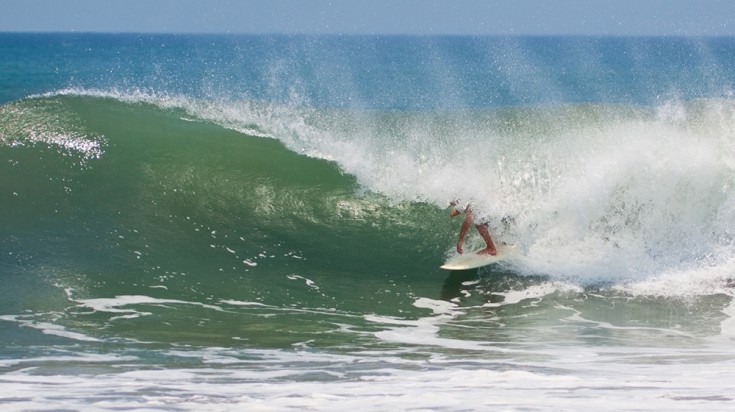 Vagues et surfeurs sur la plage de Tamarindo