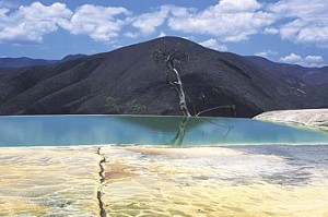 Bassin d’eau turquoise au pied d’une colline, au bord des terrasses calcaires de Hierve el Agua
