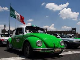 Taxi vert de Mexico devant un drapeau mexicain