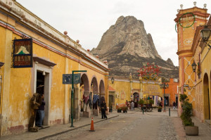 Le monolithe de la Peña de Bernal dominant une rue colorée du village de Bernal