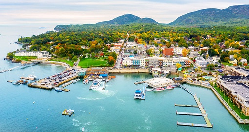 Port de plaisance et maisons de Bar Harbor au bord de l’eau, collines boisées en arrière-plan