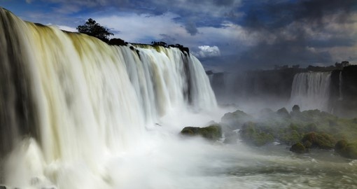 Rideaux d’eau des chutes d’Iguazú sous un ciel nuageux, à la frontière de l’Argentine et du Brésil