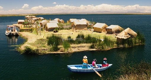 Île flottante en roseaux totora avec des huttes et une barque sur le lac Titicaca, côté péruvien près de Puno